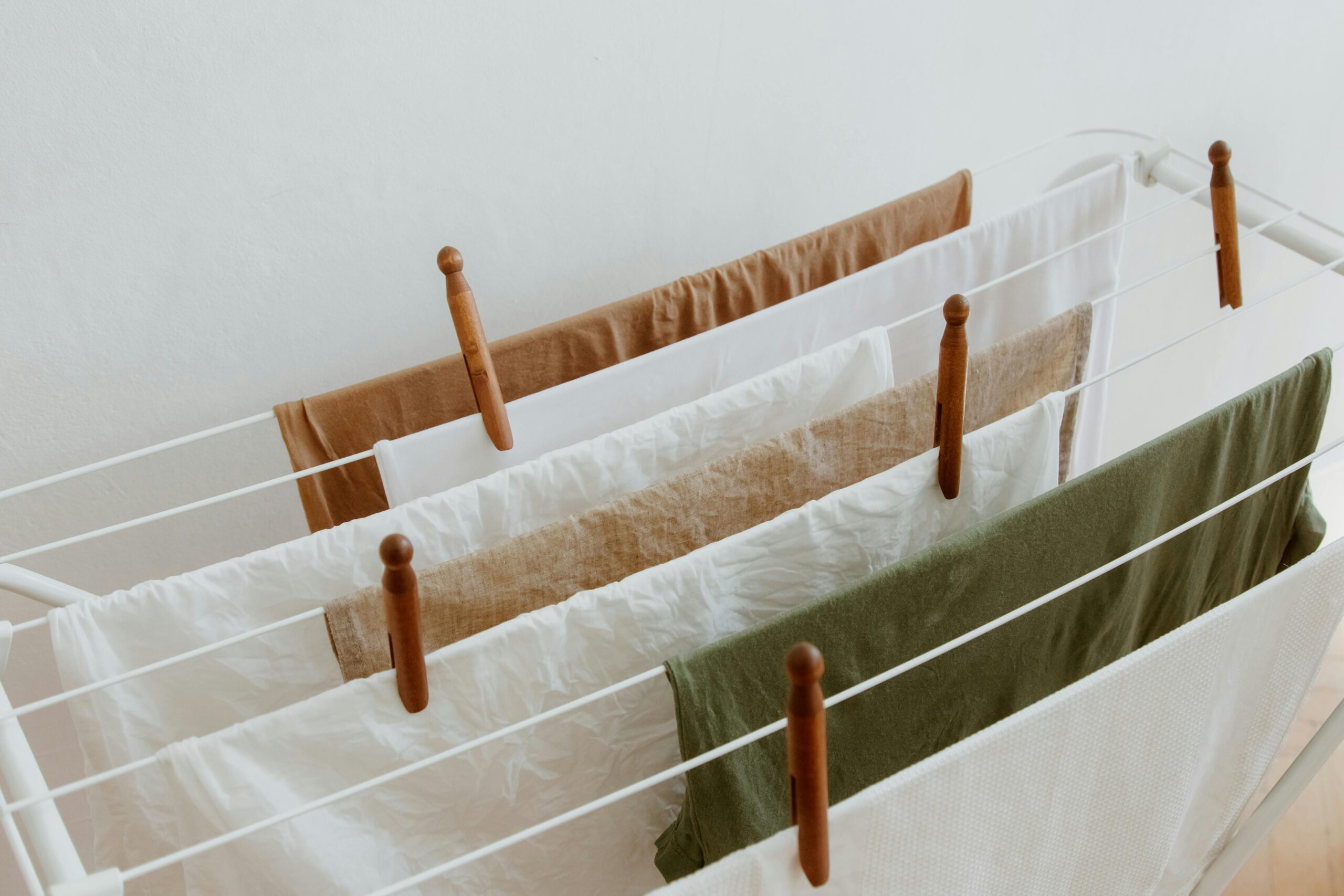 A minimalist image of clothes drying on a rack indoors, showcasing neatness and order.